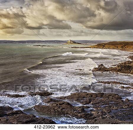 Stock Image - Scenic view of seaside landscape with waves crashing on rocky beach . Fotosearch