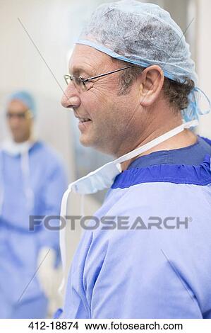 Side view of surgeon wearing glasses, blue surgical cap and gown View Large Photo Image Picture - Side view of surgeon wearing glasses, blue surgical cap and gown. Fotosearch