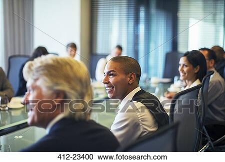 Smiling businessman attending business meeting in conference room View Large Photo Image Stock Image - Smiling businessman attending business meeting in conference room. Fotosearch