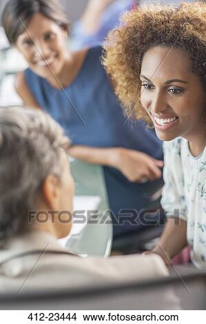 Smiling businesswomen talking in conference room View Large Photo Image Picture - Smiling businesswomen talking in conference room. Fotosearch