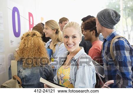 Stock Image - Smiling female student looking at camera. Fotosearch