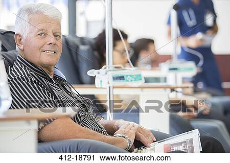 Stock Image - Smiling man undergoing medical treatment in outpatient clinic. Fotosearch