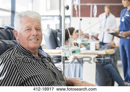 Stock Photo - Smiling senior man undergoing medical treatment in outpatient clinic. Fotosearch