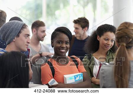 Smiling university student carrying book and looking at camera View Large Photo Image Stock Photo - Smiling university student carrying book and looking at camera. Fotosearch