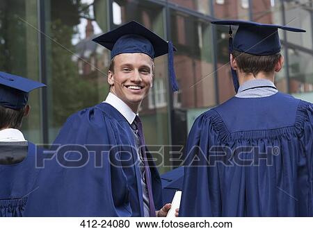 Stock Image - Smiling university student looking over shoulder at camera on campus. Fotosearch