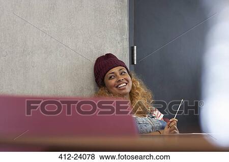 Smiling university student relaxing during break in classroom View Large Photo Image Stock Photo - Smiling university student relaxing during break in classroom. Fotosearch