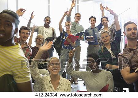 Smiling university students raising their hands at seminar View Large Photo Image Picture - Smiling university students raising their hands at seminar. Fotosearch