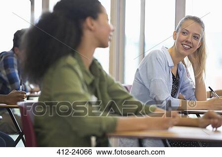 Smiling university students talking in classroom View Large Photo Image Stock Photograph - Smiling university students talking in classroom. Fotosearch
