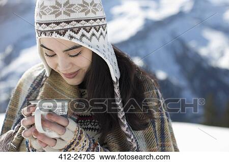 Smiling woman in knit hat drinking hot cocoa outdoors View Large Photo Image Stock Photography - Smiling woman in knit hat drinking hot cocoa outdoors. Fotosearch