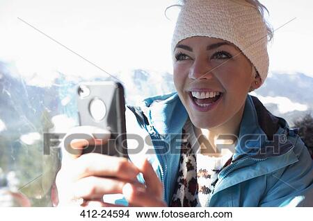 Picture - Smiling woman using cell phone. Fotosearch