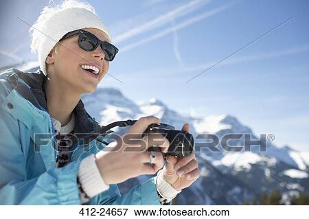 Smiling woman with camera at mountains View Large Photo Image Stock Photo - Smiling woman with camera at mountains. Fotosearch