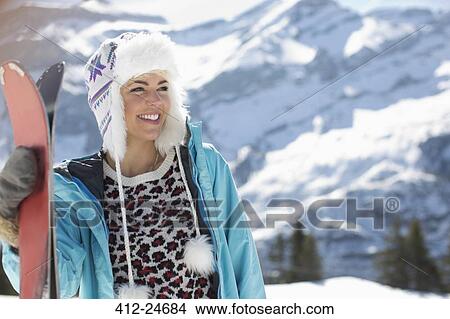 Picture - Smiling woman with skis at mountain. Fotosearch