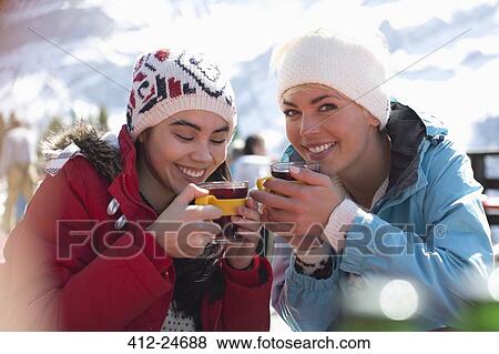 Smiling women in warm clothing drinking tea outdoors View Large Photo Image Stock Photo - Smiling women in warm clothing drinking tea outdoors. Fotosearch