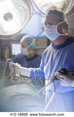 Stock Photo - Surgeon performing laparoscopic surgery in operating theater. Fotosearch
