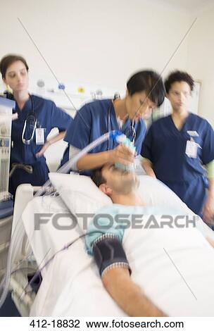 Team of doctors giving oxygen to patient in intensive care unit View Large Photo Image Stock Image - Team of doctors giving oxygen to patient in intensive care unit. Fotosearch