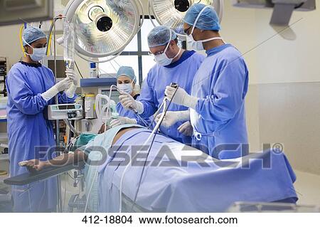 Picture - Team of doctors performing laparoscopic surgery in operating theater. Fotosearch