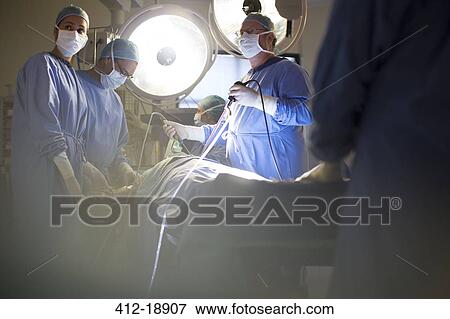 Stock Photo - Team of doctors performing laparoscopic surgery in operating theater. Fotosearch