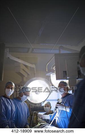 Stock Photo - Team of doctors performing laparoscopic surgery in operating theater. Fotosearch