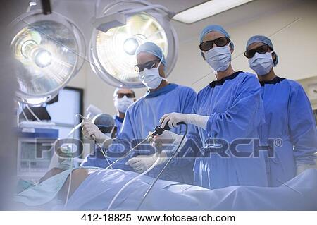 Stock Photography - Team of doctors performing laparoscopic surgery in operating theater. Fotosearch