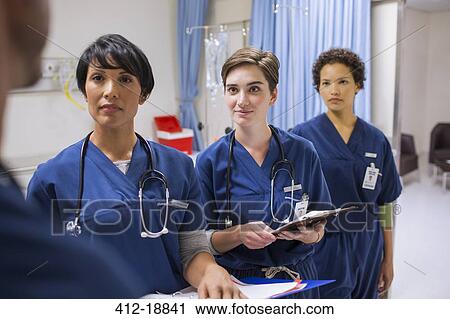 Team of female doctors wearing scrubs talking in hospital ward View Large Photo Image Stock Image - Team of female doctors wearing scrubs talking in hospital ward. Fotosearch