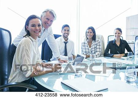 Three businesswomen and two businessmen sitting at conference table, smiling View Large Photo Image Stock Photo - Three businesswomen and two businessmen sitting at conference table, smiling. Fotosearch