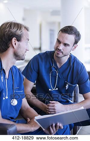 Two male doctors with stethoscopes, wearing scrubs talking in hospital View Large Photo Image Stock Photo - Two male doctors with stethoscopes, wearing scrubs talking in hospital. Fotosearch