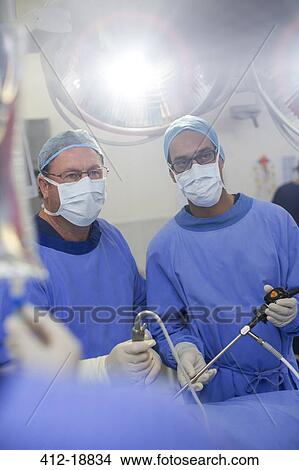 Two male surgeons wearing performing laparoscopic surgery in operating theater View Large Photo Image Picture - Two male surgeons wearing performing laparoscopic surgery in operating theater. Fotosearch