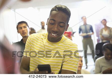 University student texting in classroom, people standing in background View Large Photo Image Stock Image - University student texting in classroom, people standing in background. Fotosearch