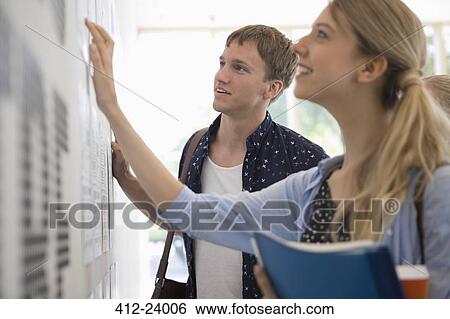 Stock Photograph - University students looking at test results in corridor. Fotosearch