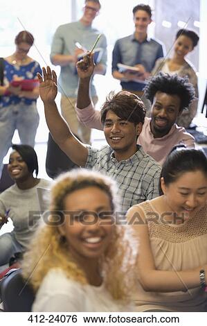 Stock Photograph - University students raising hands at IT seminar. Fotosearch
