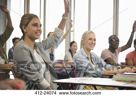 Picture - University students raising hands during seminar. Fotosearch