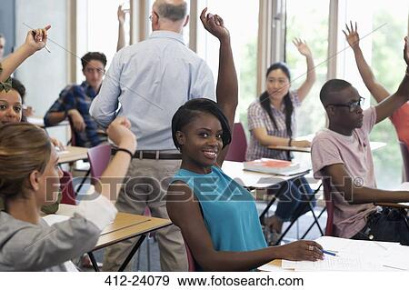 Stock Photo - University students raising hands to answer professor. Fotosearch