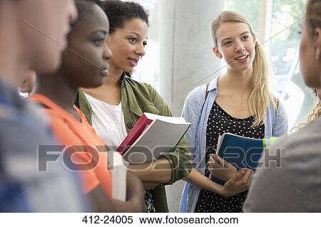 University students with books standing in corridor talking View Large Photo Image Stock Photography - University students with books standing in corridor talking. Fotosearch