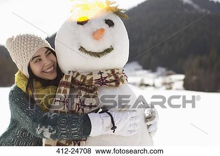 Woman hugging snowman View Large Photo Image Stock Photo - Woman hugging snowman. Fotosearch
