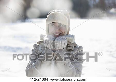 Woman in warm clothing smiling in snow View Large Photo Image Picture - Woman in warm clothing smiling in snow. Fotosearch