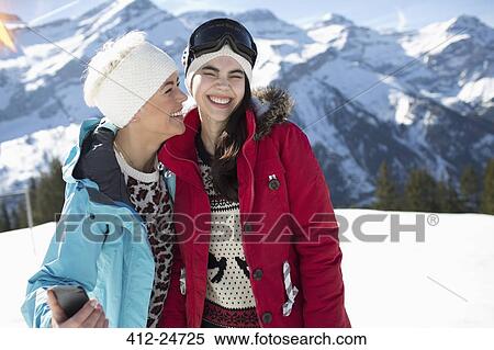 Stock Photography - Women hugging and smiling in snow. Fotosearch