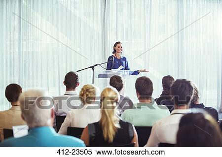 Stock Photography - Young businesswoman giving presentation in conference room. Fotosearch