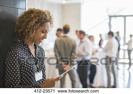 Young woman with leaning on wall while holding digital tablet View Large Photo Image Stock Image - Young woman with leaning on wall while holding digital tablet. Fotosearch