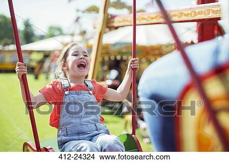 Cheerful girl laughing on carousel in amusement park View Large Photo Image Picture - Cheerful girl laughing on carousel in amusement park. Fotosearch