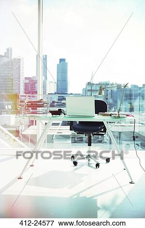 Stock Photo - Computer and rolling chair at office desk. Fotosearch