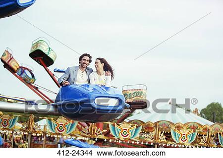 Couple enjoying ride on carousel in amusement park View Large Photo Image Picture - Couple enjoying ride on carousel in amusement park. Fotosearch