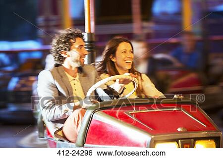 Stock Photograph - Couple on bumper car ride in amusement park. Fotosearch