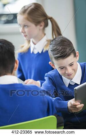 Elementary school children wearing blue school uniforms in classroom View Large Photo Image Stock Photography - Elementary school children wearing blue school uniforms in classroom. Fotosearch