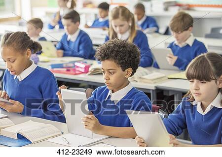Elementary school children with digital tablets in classroom View Large Photo Image Stock Photo - Elementary school children with digital tablets in classroom. Fotosearch
