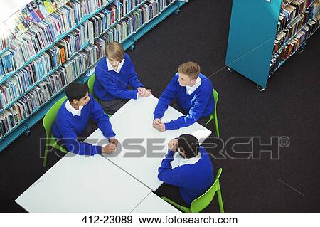 Elevated view of female and male students sitting at table in school library View Large Photo Image Stock Photo - Elevated view of female and male students sitting at table in school library. Fotosearch