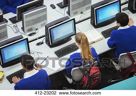 Elevated view of students sitting and learning in computer room View Large Photo Image Stock Image - Elevated view of students sitting and learning in computer room. Fotosearch