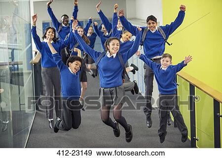 Stock Photo - Enthusiastic high school students wearing school uniforms smiling and jumping in school corridor. Fotosearch