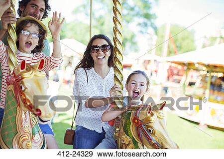 Family on carousel in amusement park View Large Photo Image Stock Photo - Family on carousel in amusement park. Fotosearch