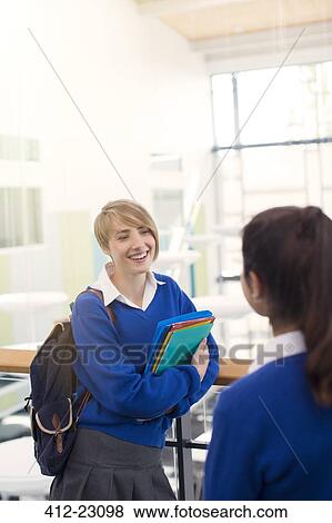 Stock Photo - Female students wearing school uniforms standing in college corridor. Fotosearch
