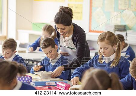 Picture - Female teacher with her pupils in classroom. Fotosearch